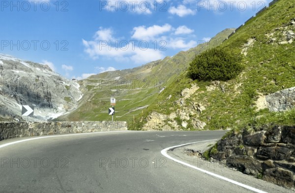 View of the hairpin bend in front with signpost 16th hairpin bend Tornante 2320 metres narrow,