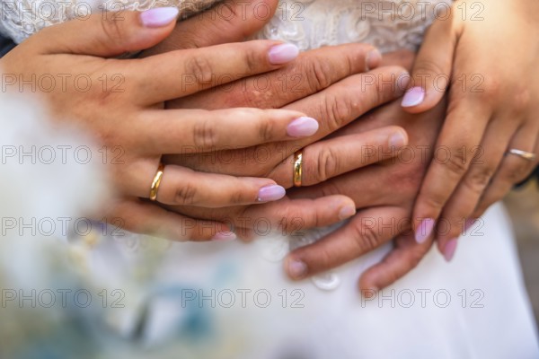 Newlyweds showing their wedding rings while embracing each other, celebrating their love and