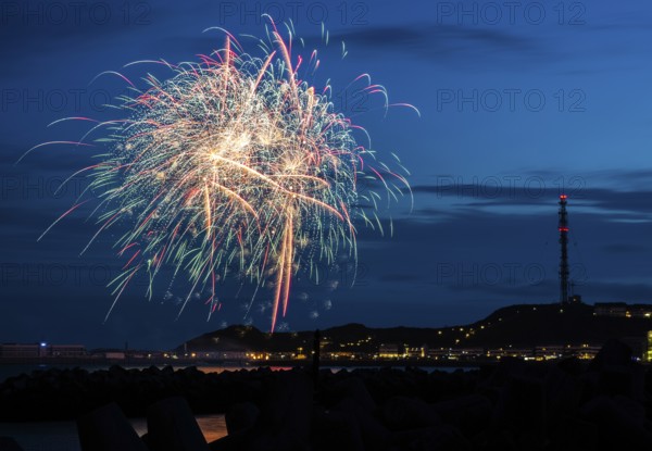 Brilliant, atmospheric fireworks display for the Heligoland island festival in red, blue and gold,