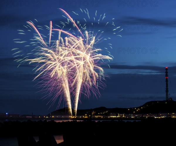 Spectacularly brilliant, atmospheric fireworks display for the Heligoland island festival in red,