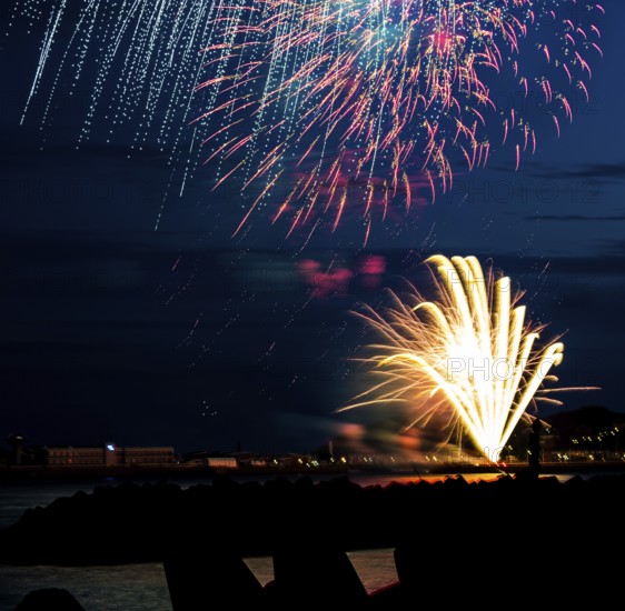 Brightly shining atmospheric fireworks for the Helgoland island festival in red, blue and gold over