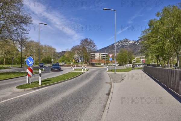Road, traffic island, roundabout, lantern, metal railing, trees, lawn, mountain landscape,