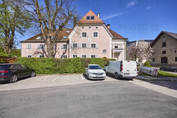 Residential building, residential house, trees, hedge, parking boxes, vehicles, blue sky,