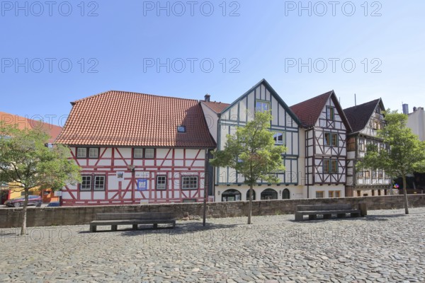 Colourful half-timbered houses, red, green, brown, empty benches, churchyard, Schmalkalden,