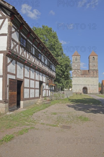Half-timbered house and Romanesque St Mary's Collegiate Church with twin towers, church ruins,