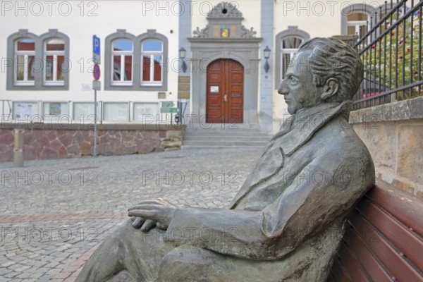 Johann Wolfgang von Goethe by Klaus Gutting sitting on the bench, arms, bronze sculpture, looking,