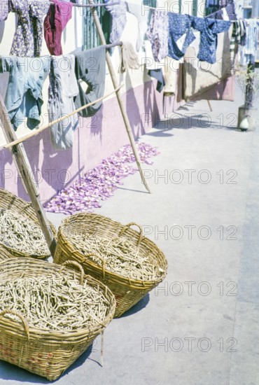 Clothes handing out to dry with baskets of what is thought to be clothes pegs, clothespins, Macau,