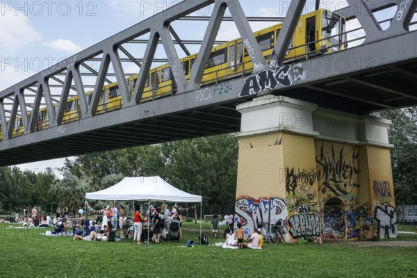Families meet for a picnic on a warm summer afternoon in Park am Gleisdreieck, Berlin, 20.07.2025,