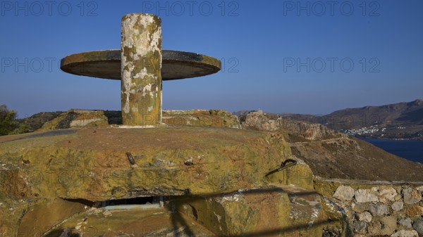 A weathered concrete platform on a hill with a sweeping sea view in a barren landscape, Lost Place,