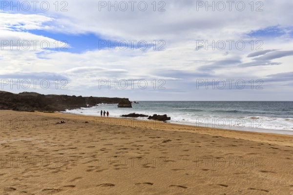 Skarðsvík Beach, walkers in a bay, golden sandy beach and rocky coast, coastal landscape,