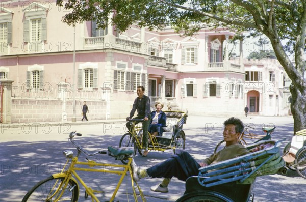 Tricycle rickshaw rider outside Governor's Palace, Portuguese colonial villa building, Avenida da