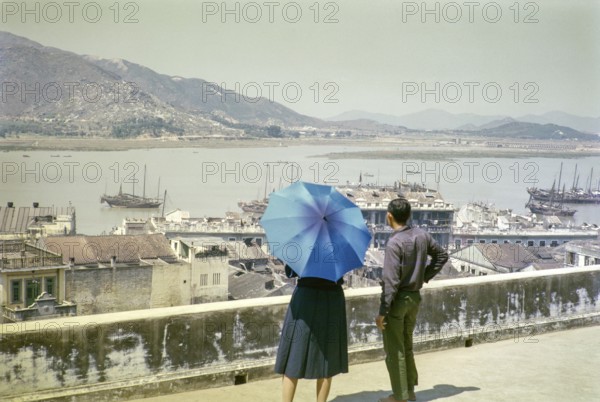 View over rooftops and harbour in city centre from hilltop of Monte Fort, Macau, Asia 1964
