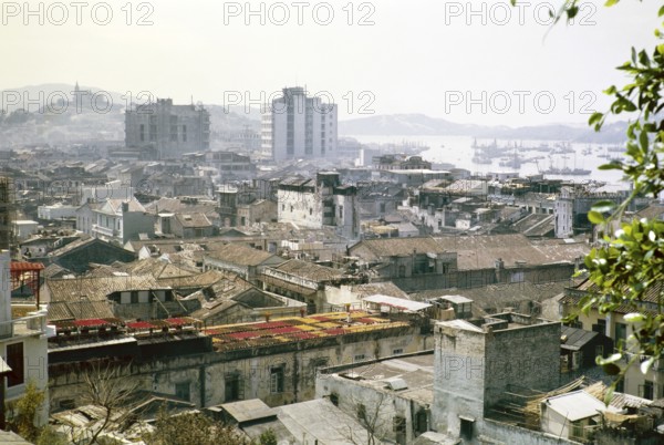 View over rooftops of high density buildings in city centre to Our Lady of Penha Chapel on hilltop