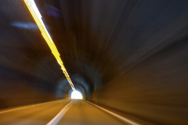 View from car while driving fast on car driver speeding car racer through long tunnel with straight