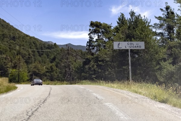 On the right tourist sign at the beginning of the mountain pass road to the Alpine pass with the