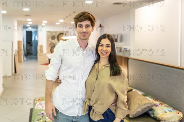 Happy couple embracing and smiling while shopping for new furniture in a vibrant home improvement