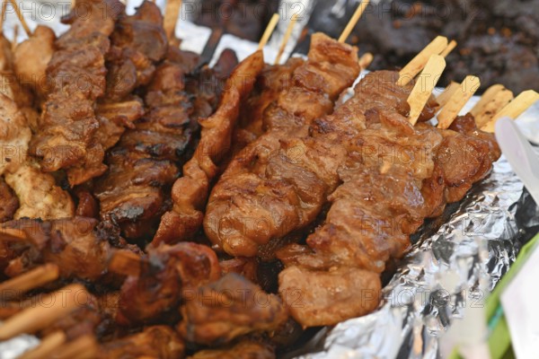 Grilled pork barbecue at Thai street food festival. Traditional Thai skewers being served at