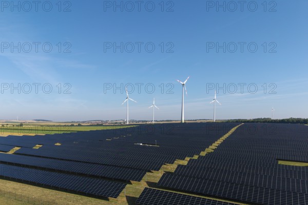 Renewable energy stations with solar panels and wind turbines in an open area, near Kitzingen,