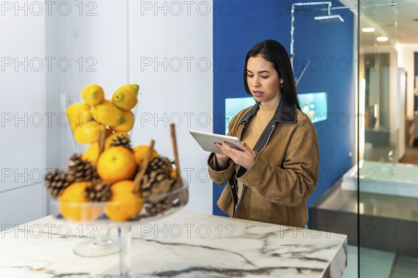 Interior designer using digital tablet while working in bathroom decor section of home improvement