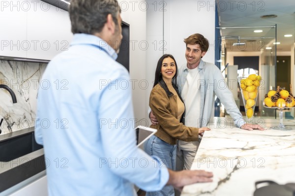 Happy couple and interior designer discussing kitchen countertop options in home improvement store