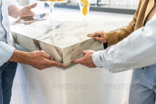 Architects examining a marble countertop joint in a home improvement store, discussing design