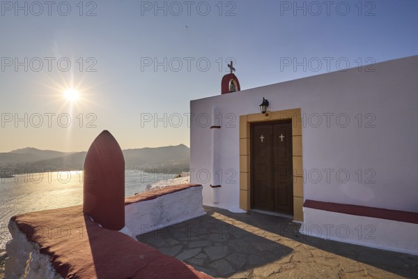 Chapel with a view of the sea at sunset, classic Mediterranean architecture, red-painted world war