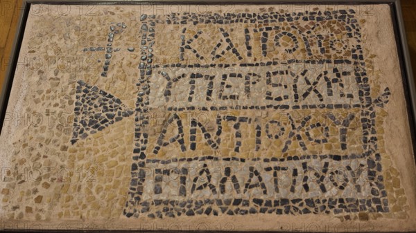 Ancient mosaic with ancient inscription and geometric patterns made of small stones, Archaeological