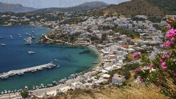 View of a Greek coastal town with flowers and yachts surrounded by blue sea, Pandeli Castle,