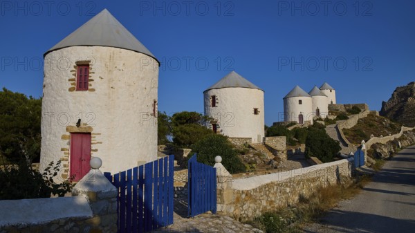 Four windmills behind a blue gate, along a road, Pandeli Castle, Castle, Leros Fortress, St John's