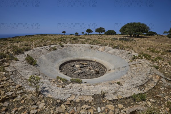 Large concrete crater in an open, rocky landscape under a clear sky, Lost Place, Air Defence