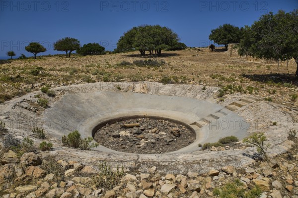 Round crater in a barren landscape with some trees on the horizon, Lost Place, Air Defence