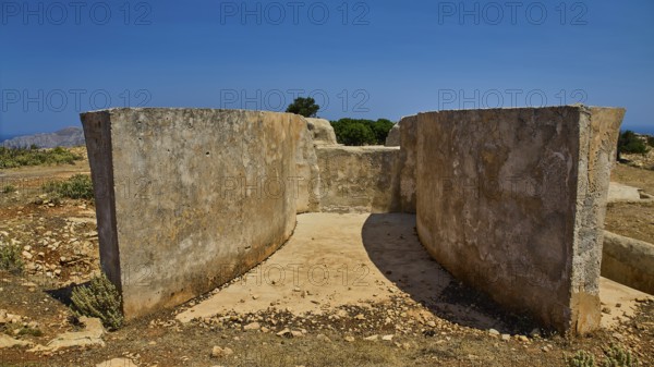 Small concrete structure with vegetation and clear sky in an arid landscape, Lost Place, Air