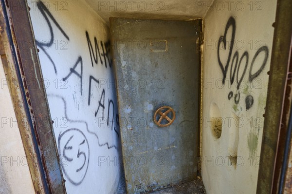 Lost Place, Small room with graffiti-covered metal door and worn appearance, Radio Station, WW2,