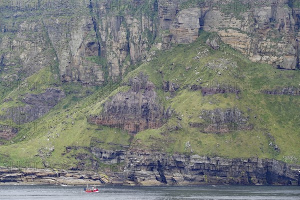 Steep cliffs and a tiny fishing boat convey a sense of grandeur, Hoy, Orkney Islands, Scotland,