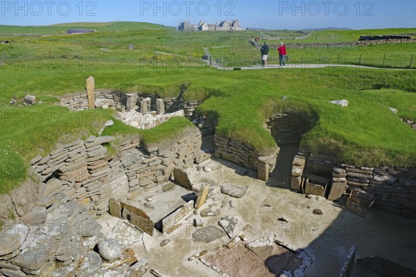Wide view of an archaeological site with ruins in grassy landscape, Skara Brae, Neolithic