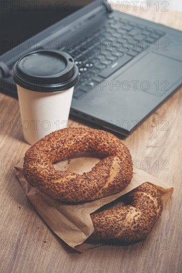 Simits with coffee on a wooden table, with a laptop, in a cozy working environment, snack,