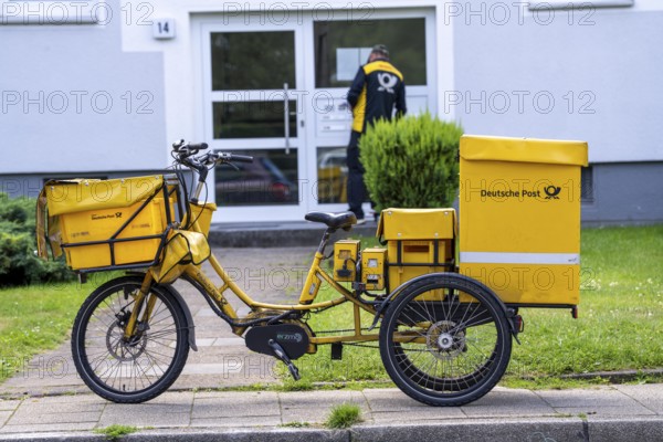 Postman, Deutsche Post, distributes the mail in an apartment building, electric tricycle, North