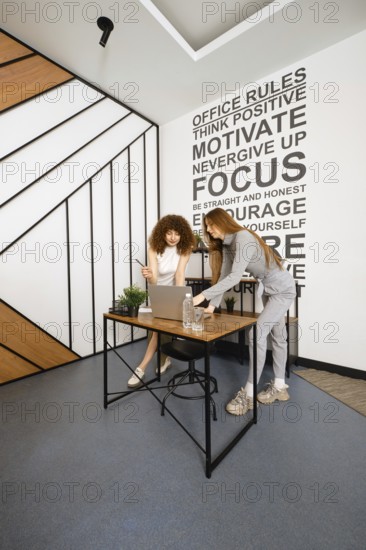 Two women work together in a stylish office dedicated to women's health, discussing plans and