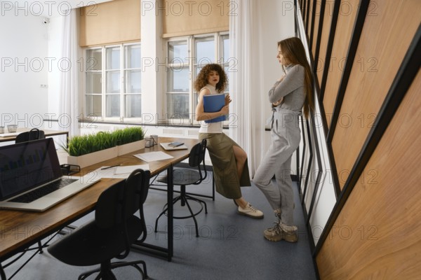 Two women are discussing the user interface of their health monitoring app in a stylish startup