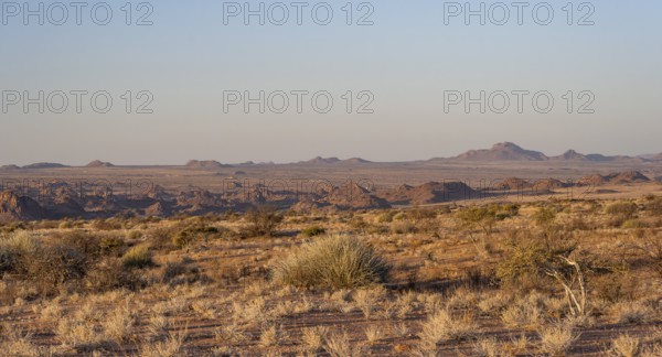Desert landscape in the evening light at sunset, barren landscape with hills of stacked rocks,