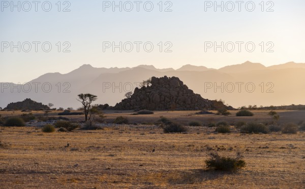 Desert landscape in the evening light at sunset, barren landscape with hills of stacked rocks,
