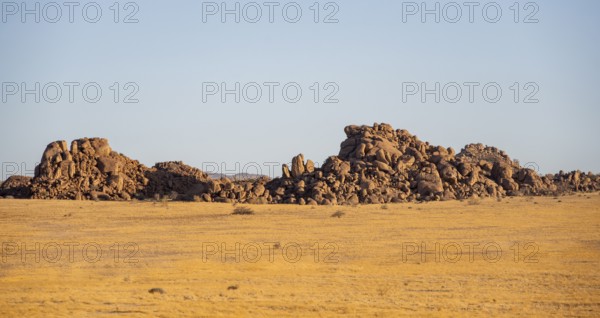 Barren landscape with hills of stacked rocks, desert landscape in the evening light at sunset,