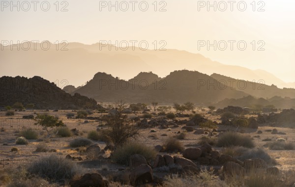 Barren landscape with hills of stacked rocks, desert landscape in the evening light at sunset,