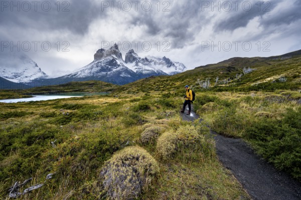 Hikers on the way to the Mirador de los Cuernos, Cuernos del Paine mountain range, dramatic sky,