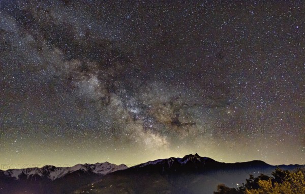 Starry sky with Milky Way above the mountain peaks in Valais, Switzerland