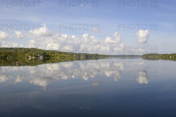 View over the Möhnesee, Möhnesee tower, red and white buoy, blue cloudy sky, reflection on the