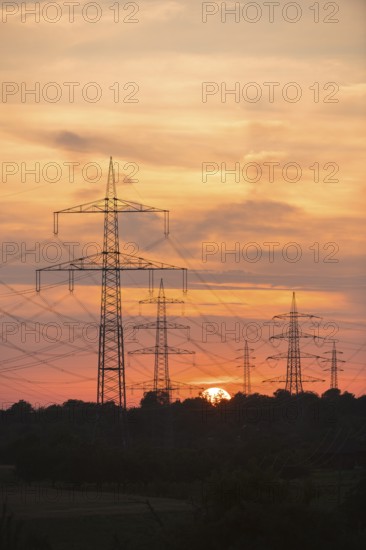 Dramatic silhouettes of electricity pylons against a colourful sky, Waiblingen, Baden-Württemberg,