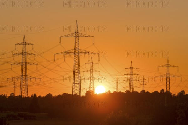 Electricity pylons in front of a glowing sunset on the horizon, Waiblingen, Baden-Württemberg,