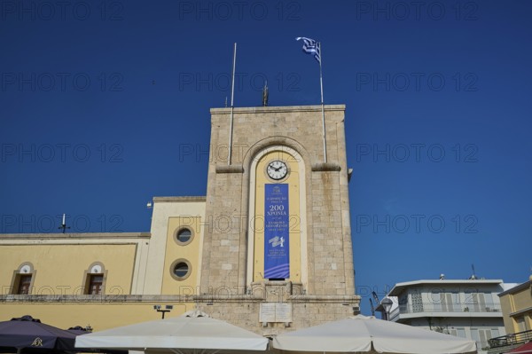 Cinema, Eleftherias Square, Historic clock tower with Greek flag against a clear sky, Kos Town,
