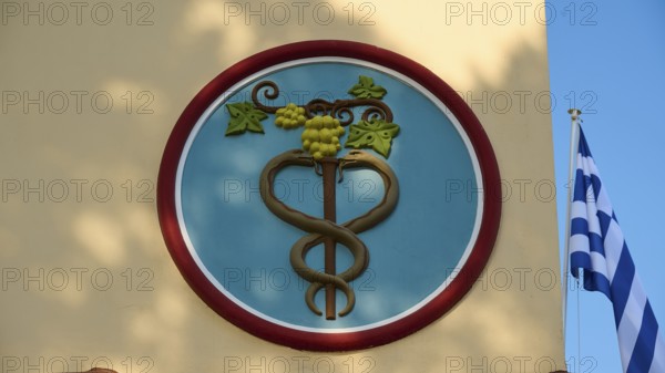 Town Hall, circular emblem with snake and vine, flanked by Greek flag, Kos Town, Kos, Dodecanese,